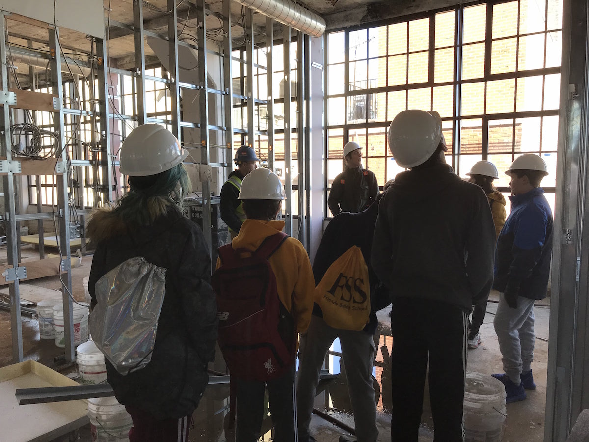 Group of young people taking a tour of a building under construction.