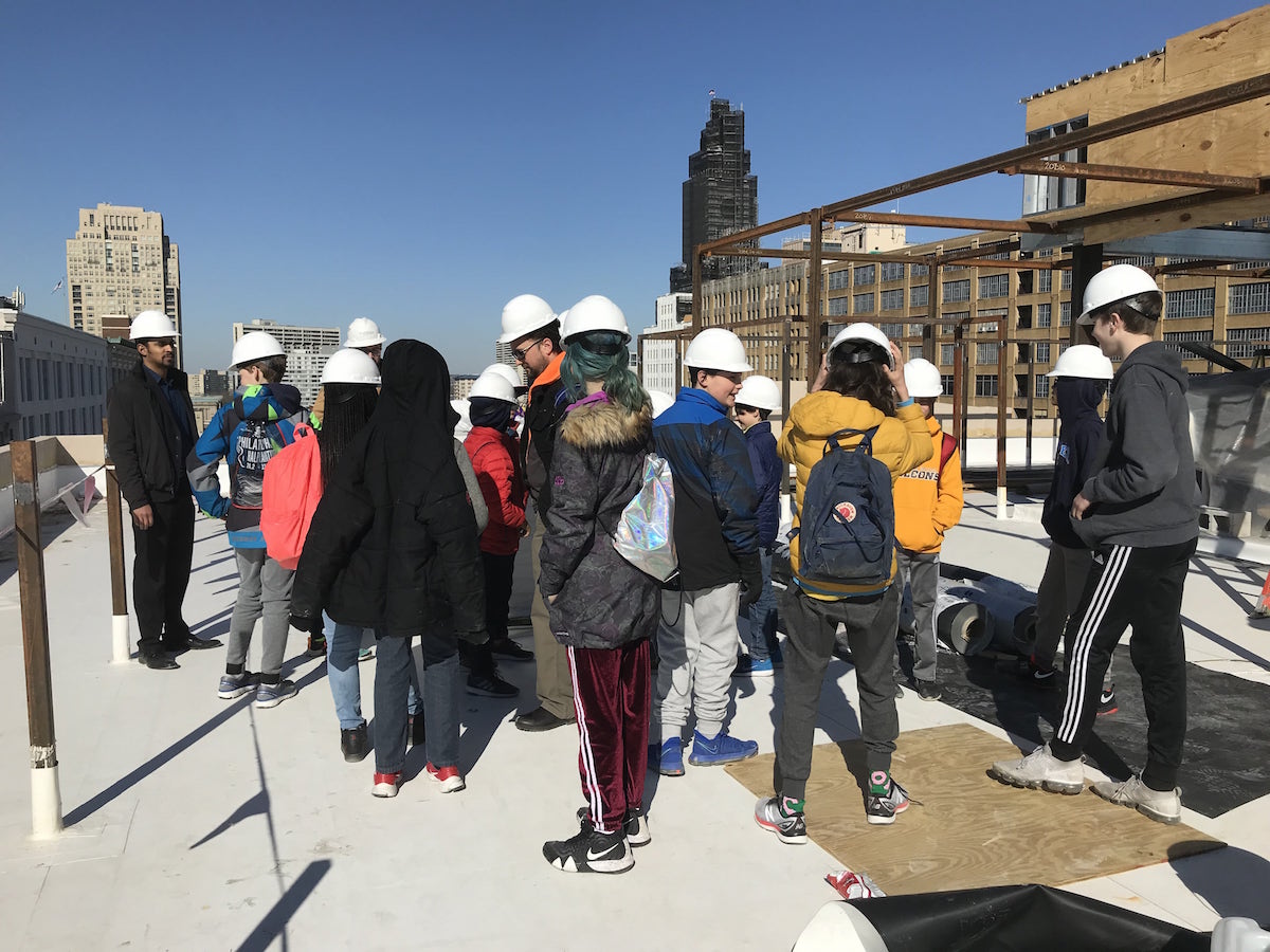 Group of young students on the roof of the construction building.