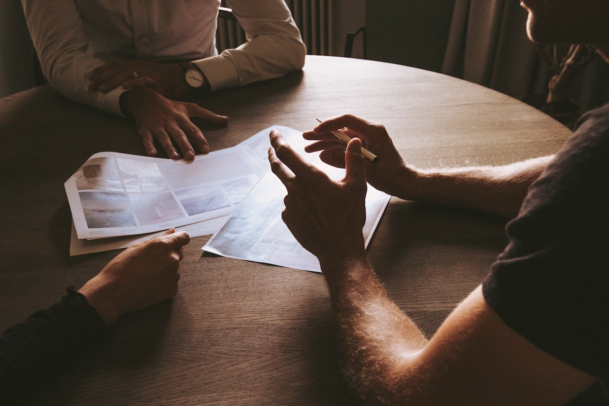 A group of professionals sitting around a table discussing a plan.