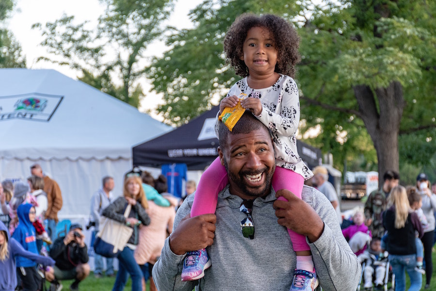 Man carrying child at fall festivals in Philly