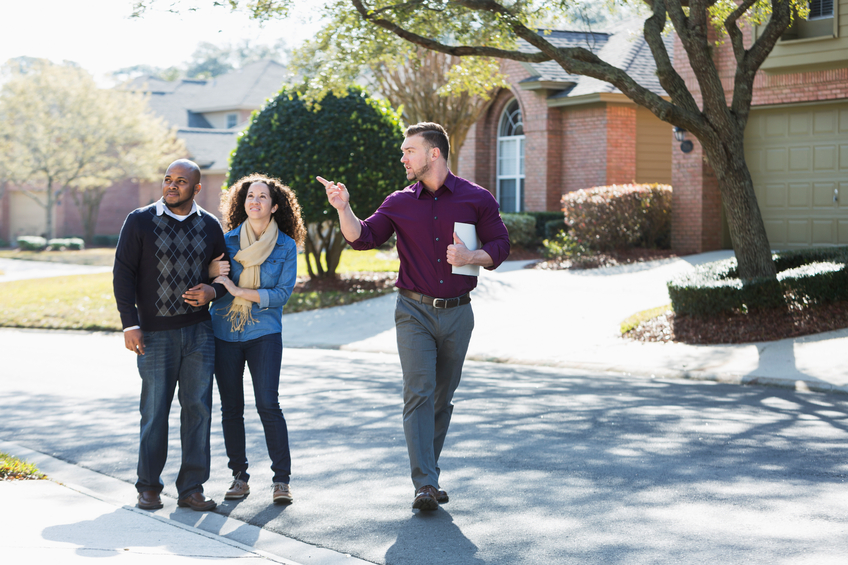 An agent leading potential buyers on a tour of homes.